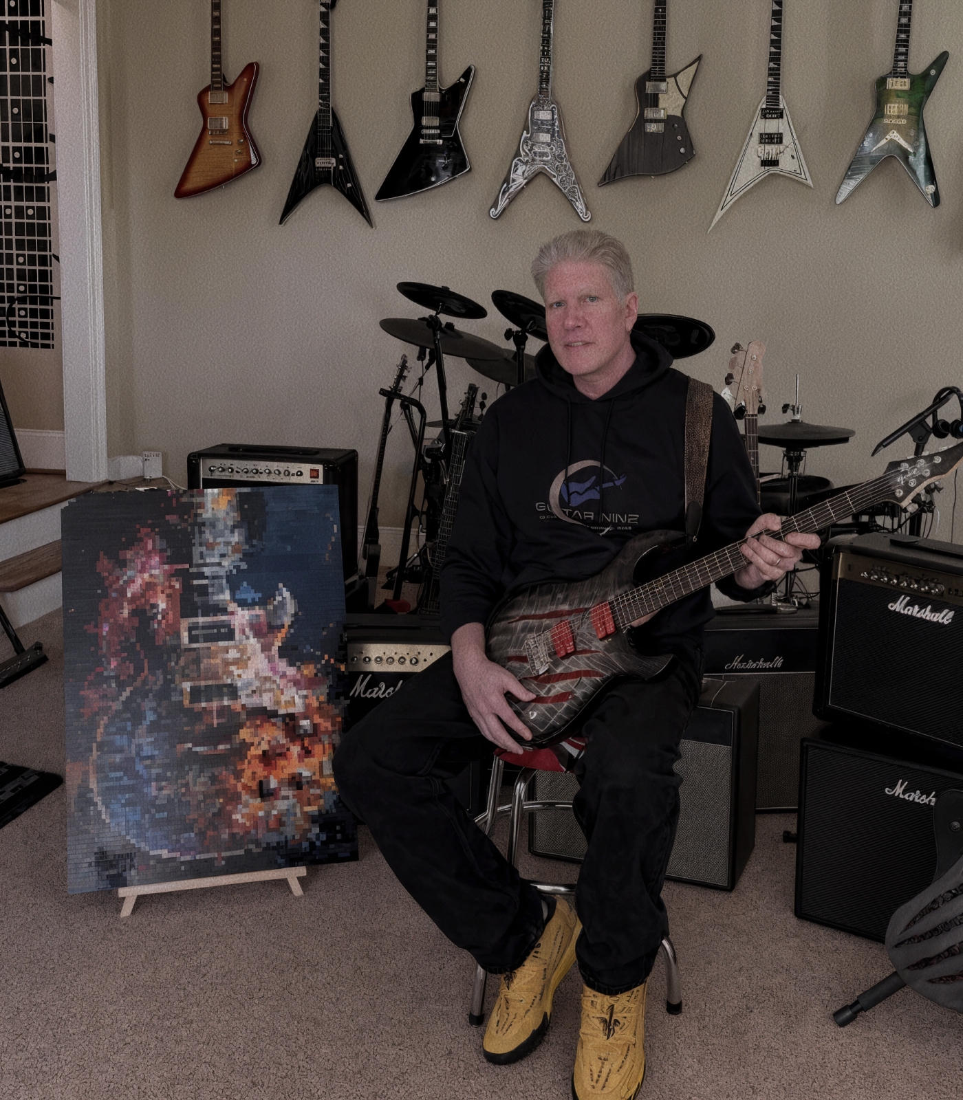 The gear as a mass rather than one instrument — a wall of guitars, a pedalboard mid-build, the room with everything in it. Portrait. It should look like more than anyone needs, because that is the joke the section is telling.